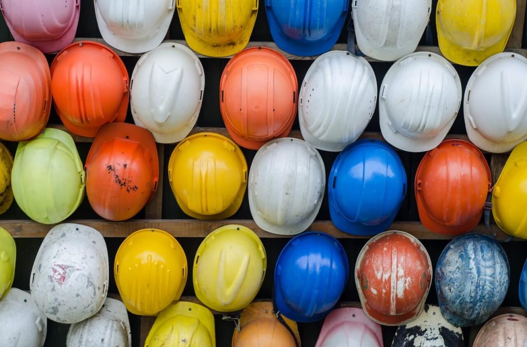 mosaic of multicolored construction helmets